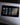 Image of OLED display of Graphene Powerbank, Flash Pro Plus, with 25000mAh large battery capacity, OLED display, USB-C 100W fast charging. An iPhone 14 is being charged on the MagSafe compatible wireless charging up to 15W. An Apple Watch is being charged on the separate Apple Watch charging pad supporting up to 5W. Perfect for Apple users on the go.