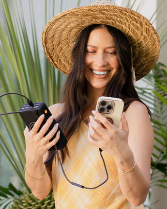 Woman charging her iPhone from the Flash Pro Ultra power bank by cable