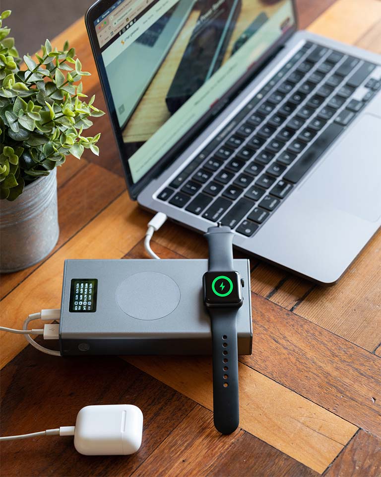 Image of Graphene Powerbank, Flash Pro Plus charging Airpods, Macbook and Apple Watch. 25000mAh large battery capacity, OLED display, USB-C 100W fast charging. An iPhone 14 is being charged on the MagSafe compatible wireless charging up to 15W. An Apple Watch is being charged on the separate Apple Watch charging pad supporting up to 5W. Perfect for Apple users on the go. 