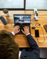 white universal travel adapter with GaN technology charging a laptop